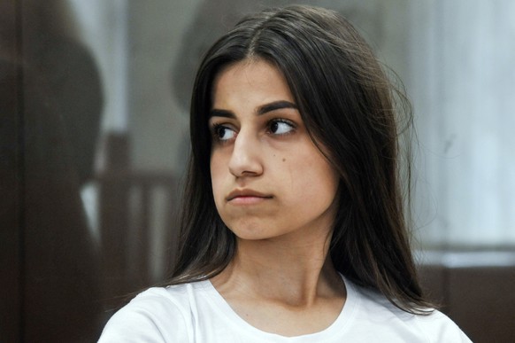 In this photo taken on Wednesday, June 26, 2019, Angelina Khachaturyan attends hearings in a court room in Moscow, Russia. Three Khachaturyan sisters, now aged 18, 19 and 20, face charges for the prem ...