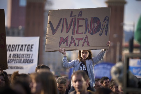 A girl holds a banner reading &quot;housing killing&quot; as people gather during a demonstration to protest high housing costs in Barcelona, Spain, Saturday, April 5, 2025. (AP Photo/Emilio Morenatti ...