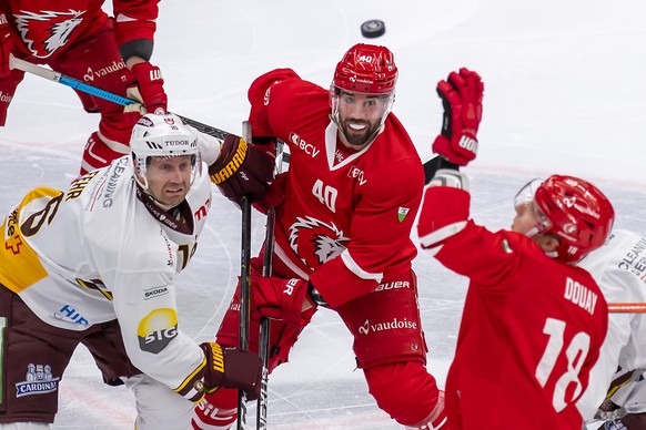 L?attaquant genevois Eric Fehr, gauche, a la lutte pour le puck avec l&#039;attaquant lausannois Etienne Froidevaux, droite, lors du match du championnat suisse de hockey sur glace de National League  ...