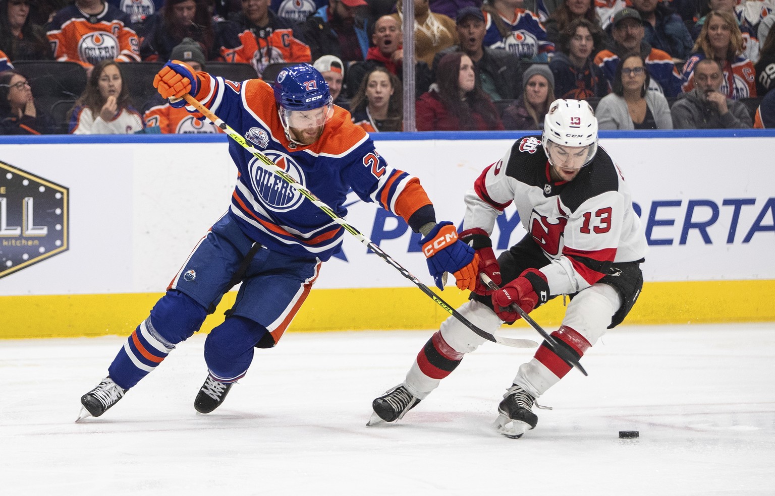 New Jersey Devils' Nico Hischier (13) and Edmonton Oilers' Brett Kulak (27) vie for the puck during the third period of an NHL hockey game Thursday, Nov. 3, 2022, in Edmonton, Alberta. (Jason Franson/ ...