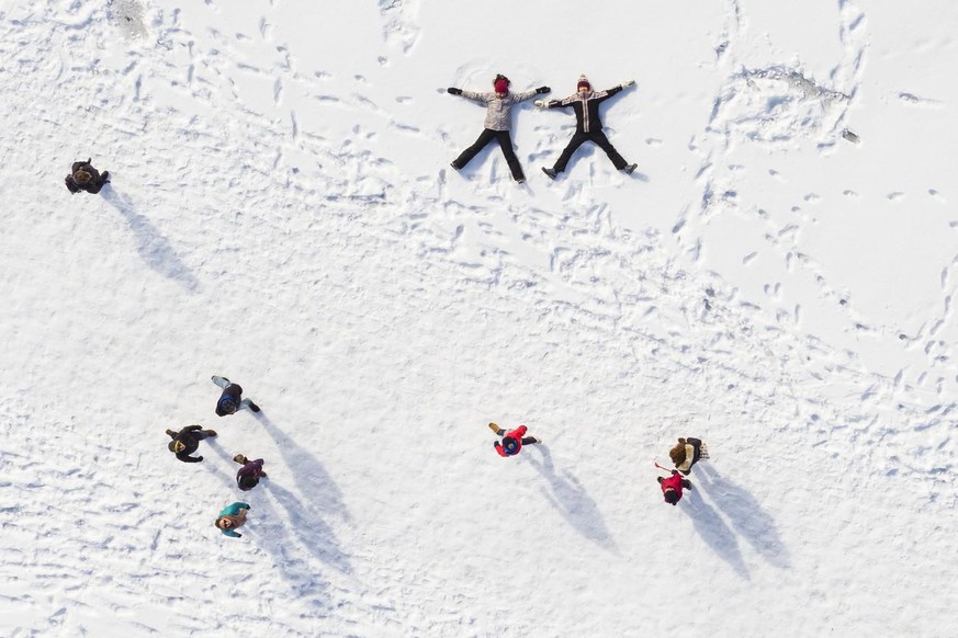 Kinder spielen auf dem zugefrorenen See Lac de Joux im März 2018 im Schnee.