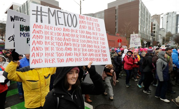 FILE - In this Saturday, Jan. 20, 2018 file photo, a marcher carries a sign with the popular Twitter hashtag #MeToo used by people speaking out against sexual harassment as she takes part in a Women&# ...