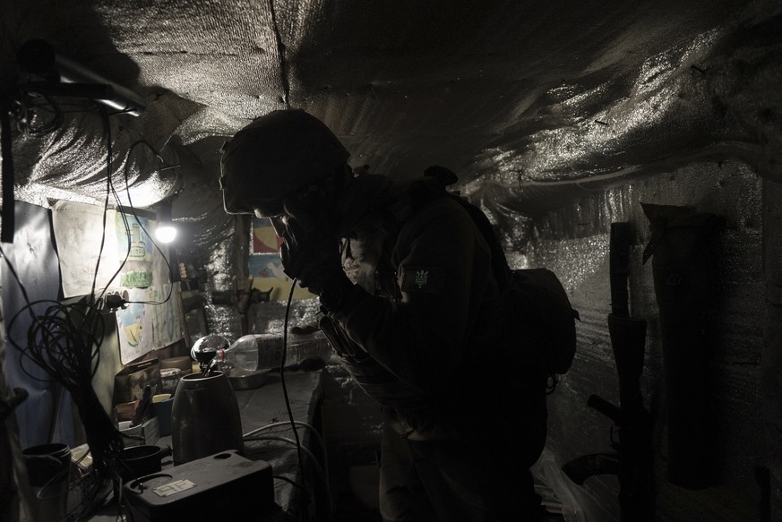 Zakhar Leshchyshyn, a Ukrainian serviceman, reports to a commander via military intercom while in a shelter at the frontline positions near Zolote, Ukraine, Saturday, Feb. 19, 2022. Leshchyshyn's ...
