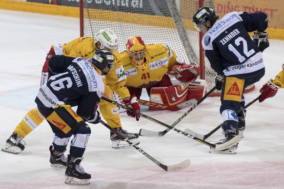 Torhueter Elien Paupe, mitte, von Biel im Spiel gegen Lino Martschini, links, und Yannick Lammer, rechts, von Zug beim Eishockey Meisterschaftsspiel in der Qualifikation der National League zwischen d ...