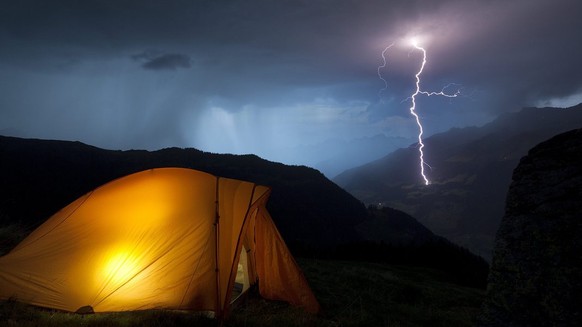 Ein Blitz schlaegt in eine Lichtung in einem Maiensaess oberhalb S. Benedegt im Buendner Oberland ein, beobachtet von einem Zelt am Piz Titschal aus, in der Nacht vom Dienstag auf den Mittwoch, 23. Au ...
