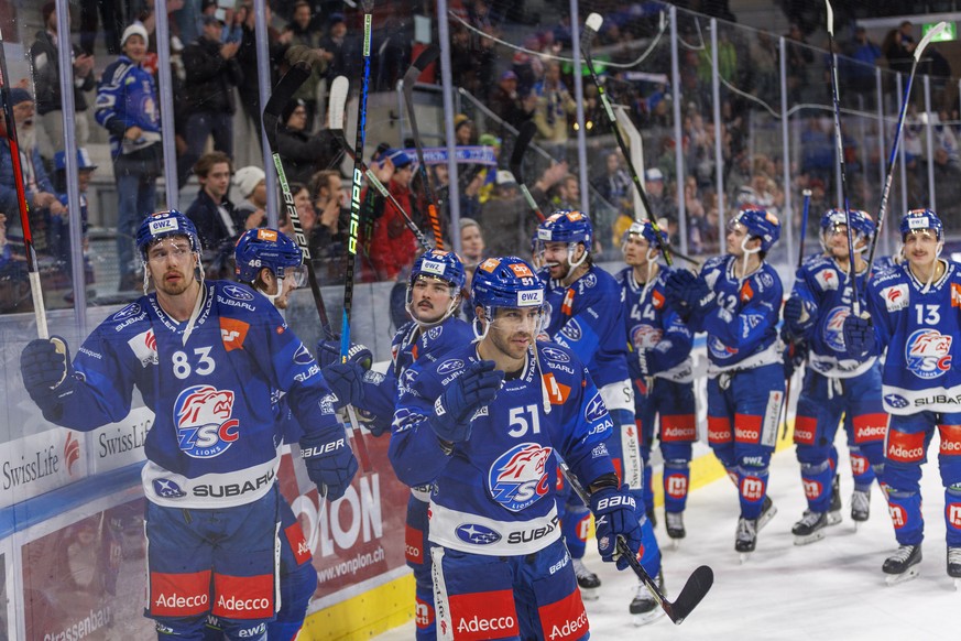 ZSC Lions Stuermer Juho Lammikko (#83), Stuermer Justin Azevedo (#51) und ihre Teamkollegen feiern den 3-2 Sieg nach dem Eishockey-Meisterschaftsspiel der National League zwischen den ZSC Lions und de ...