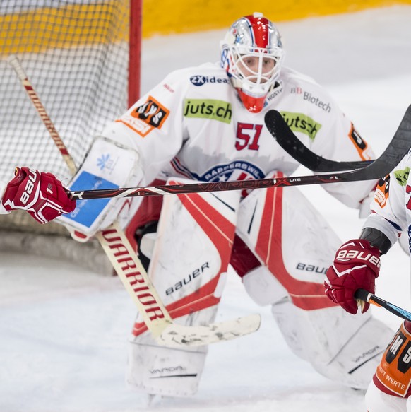 L&#039;attaquant lausannois Christoph Bertschy, gauche, lutte pour le puck avec le joueur de Rapperswil Sven Berger, droite, sous le regard du gardien de Rapperswil Noel Bader, centre, lors de la renc ...