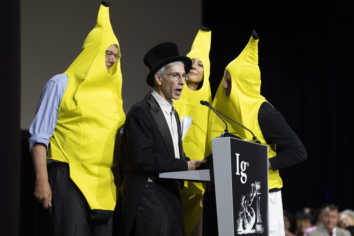 epa13210186 American mathematician and scientific editor Marc Abrahams (C) speaks surrounded by people dressed up as bananas during the 36th First Annual Ig Nobel Prize ceremony held in the Zurich Con ...
