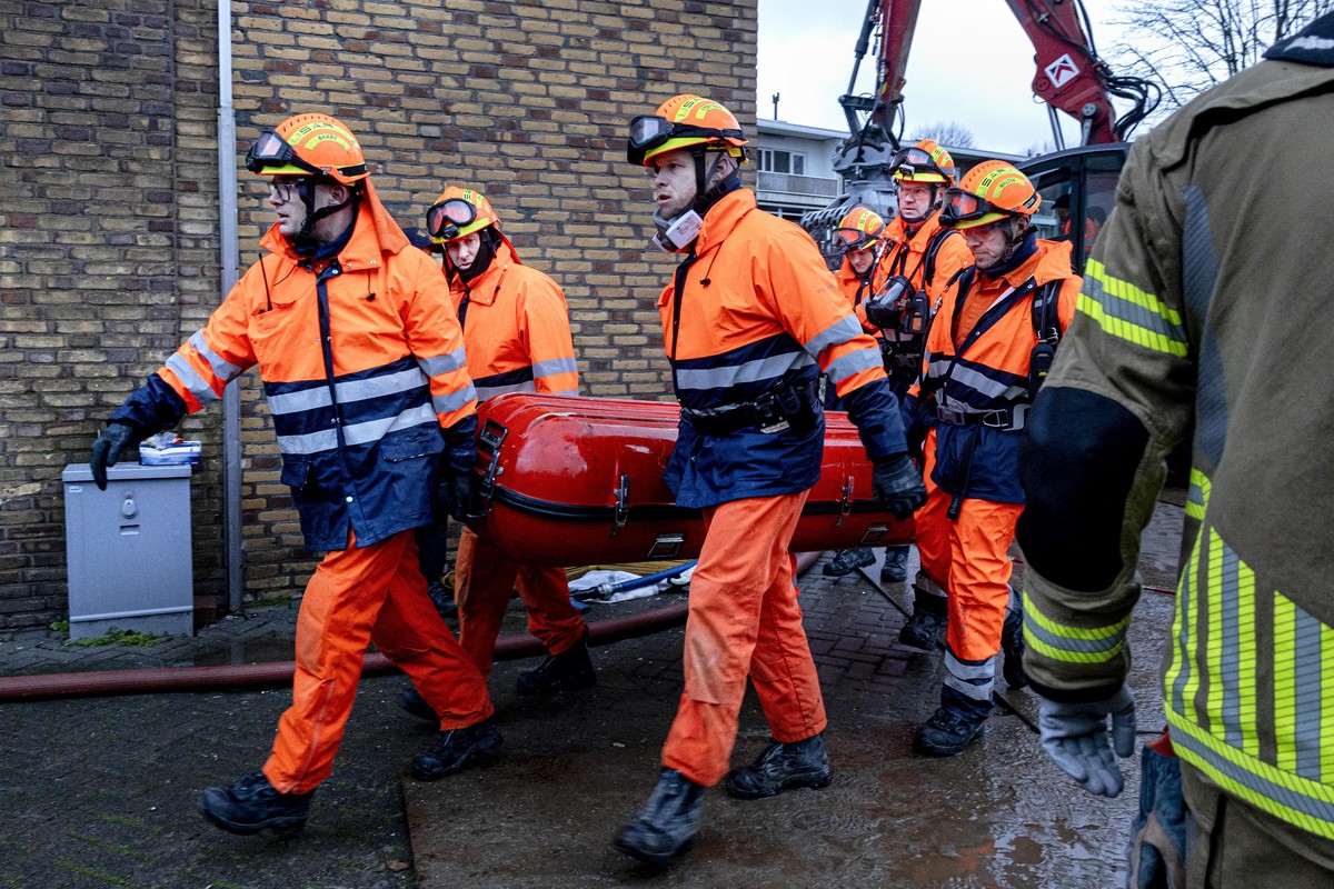 epa11762269 Rescuers work carry a body found at the site of a partially collapsed building after a fire and an explosion, in The Hague, The Netherlands, 07 December 2024. A three-storey apartment buil ...
