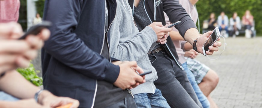 ARCHIVBILD ZUM ENTSCHEID DES BUNDESRATES GEGEN ZU HOHE ROAMING-TARIFE VORGEHEN ZU WOLLEN, AM DONNERSTAG, 7. SEPTEMBER 2017 - A group high school students use their smart phones on the schoolyard of th ...