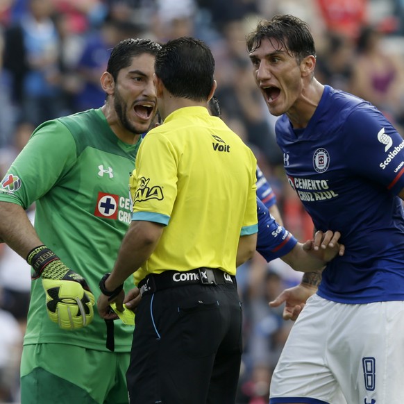 Cruz Azul goalie Jose de Jesus Corona, center left, and Gabriel Penalba complain to referee Jose Alredo Penaloso Soto after calling a penalty during a Mexico soccer league match in Mexico City, Saturd ...