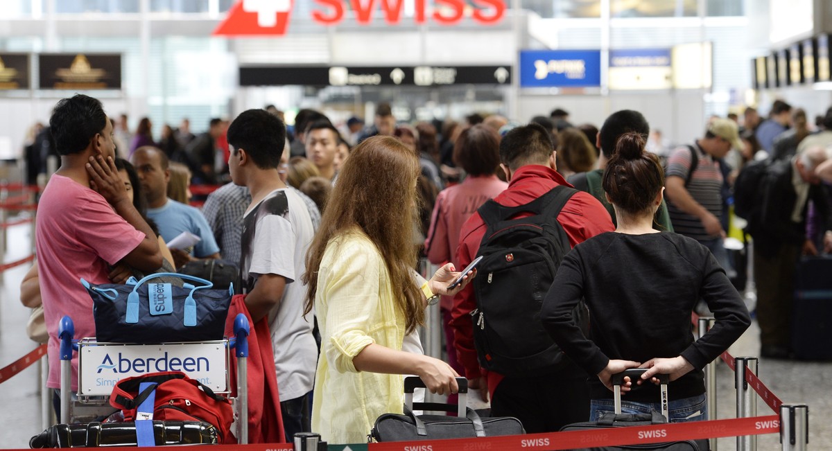 Am 12. Juli warten Passagiere an der Gepäckabgabe vom Flughafen Zürich.