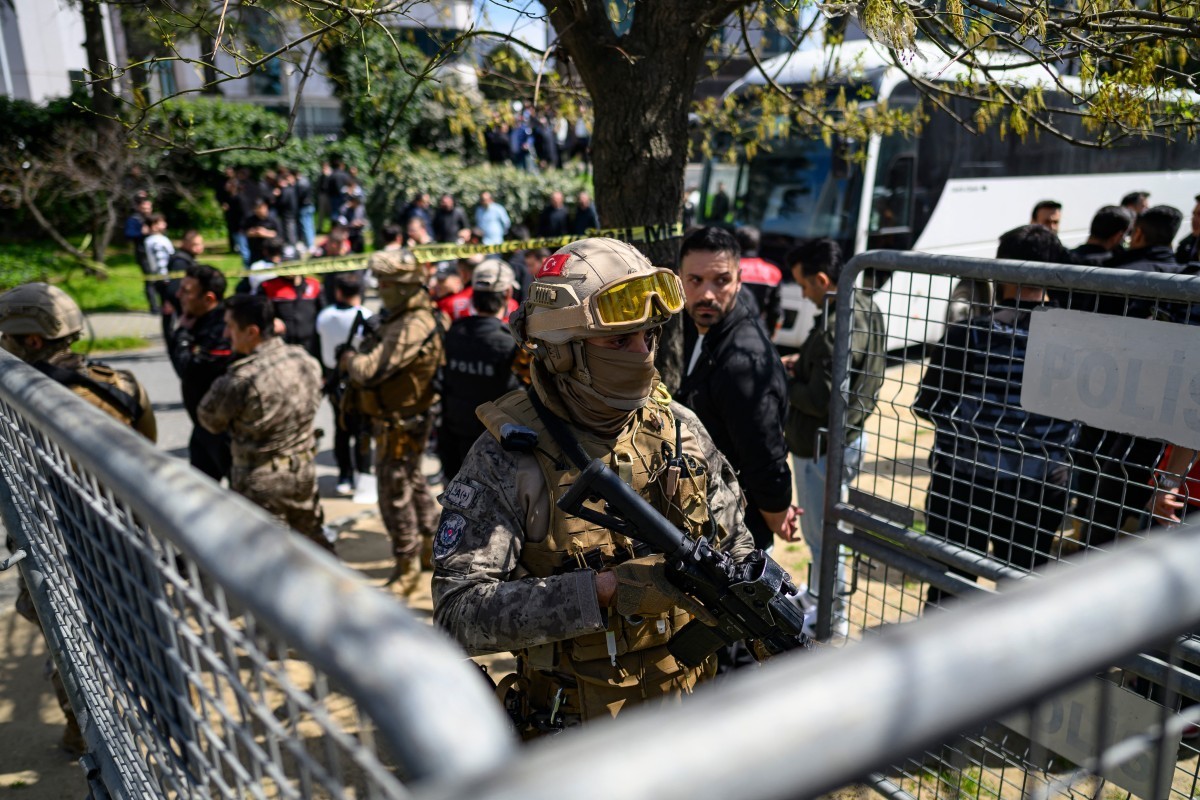 A police official stands alert near The Israeli Consulate in Istanbul on April 7, 2026, following a shootout between gunmen and police. One gunman was killed and two others were wounded in a shootout  ...
