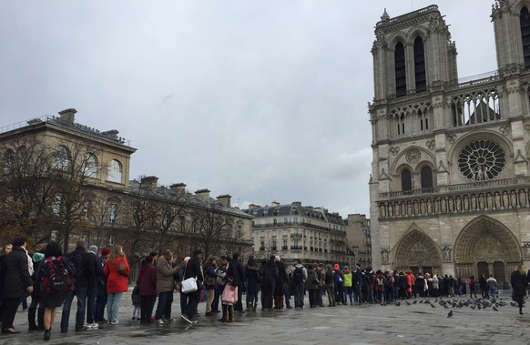 Vor der Notre Dame stehen die Touristen Schlange – so wie immer.<br data-editable="remove">
