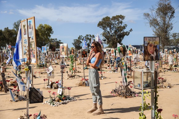 epa11641457 A woman looks at pictures and memorials for Israeli festival goers who killed by Hamas at the site of the Supernova Music Festival rave near Kibbutz Reim, Southern Israel, 19 September 202 ...