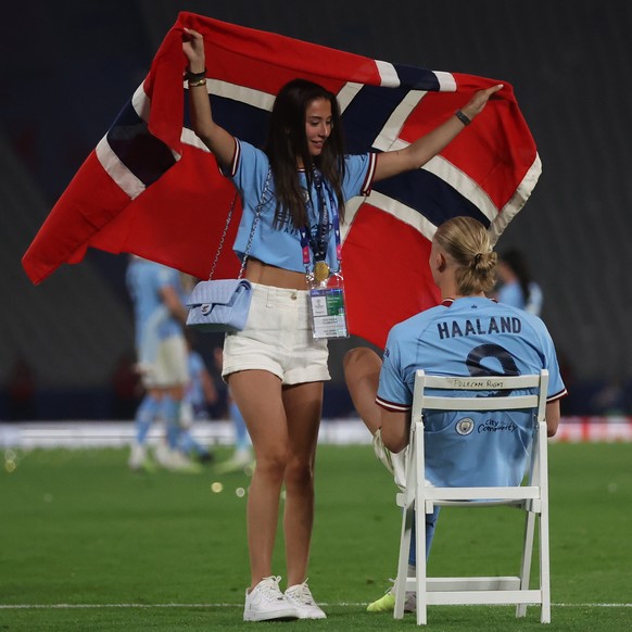 epa10684509 Erling Haaland of Manchester City and his girlfriend Isabel Johansen on the pitch after winning the UEFA Champions League Final soccer match between Manchester City and Inter Milan, in Ist ...