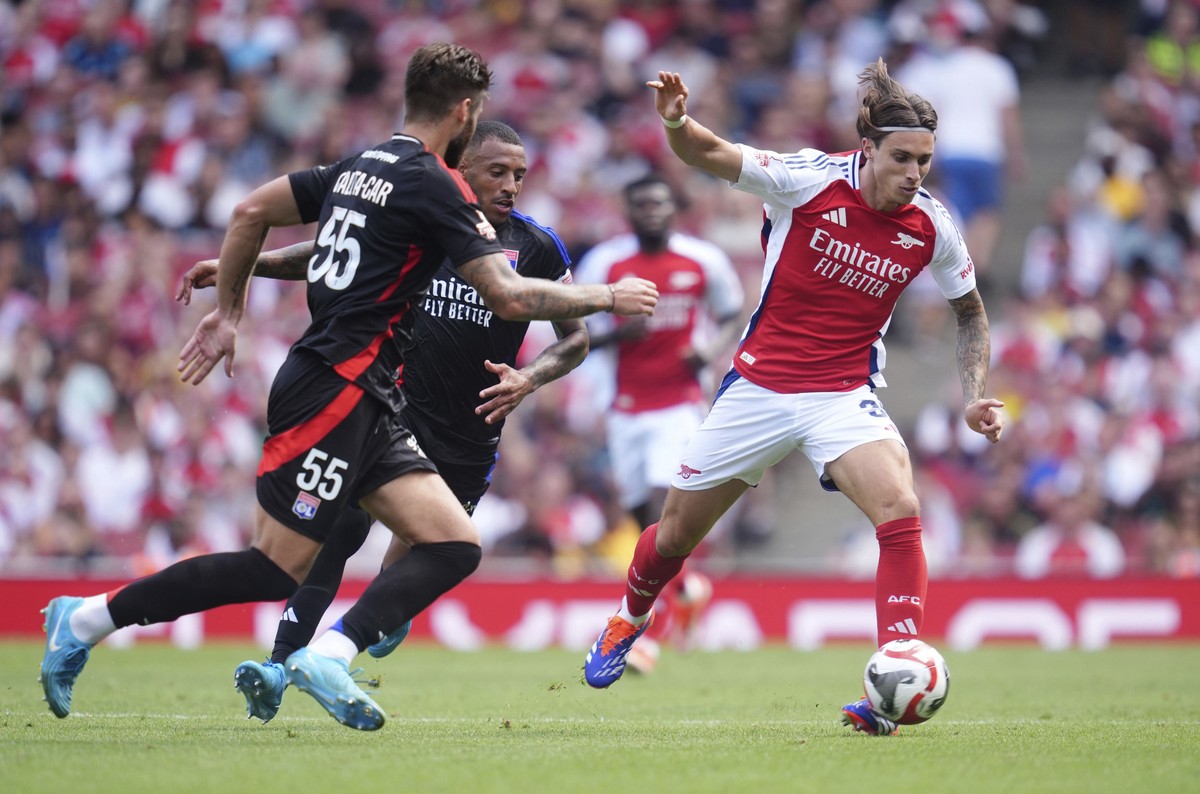 Lyon's Duje Caleta-Car, left, and Arsenal's Riccardo Calafiori challenge for the ball during the friendly soccer match between Arsenal and Olympique Lyon at the Emirates Stadium, London, Sun ...