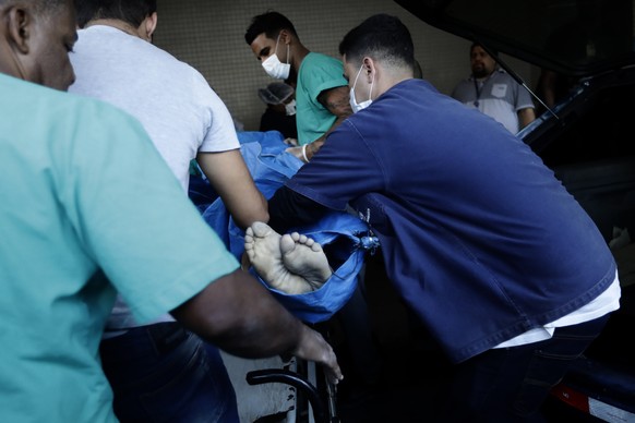 A person killed during a police raid of the Vila Cruzeiro favela is placed on a gurney at the Getulio Vargas Hospital, in Rio de Janeiro, Brazil, Tuesday, May 24, 2022. Police raided the favela before ...