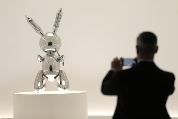 A man takes a picture of a sculpture entitled &quot;Rabbit&quot; by Jeff Koons during a media preview at Christie&#039;s in New York, Friday, May 3, 2019. This sculpture along with other artworks will ...