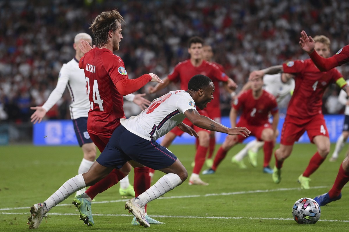 England's Raheem Sterling, left, is fouled by Denmark's Mathias Jensen and a penalty is awarded during the Euro 2020 soccer semifinal match between England and Denmark at Wembley stadium in  ...