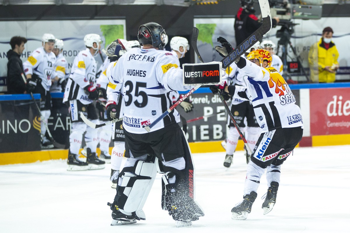 Fribourg-Gotteron PostFinance Top Scorer Christopher DiDomenico, rechts, feiert seine Siegestreffer in der Verlaengerung mit Torhueter Connor Hughes waehrend dem Eishockey-Meisterschaftsspiel der Nati ...