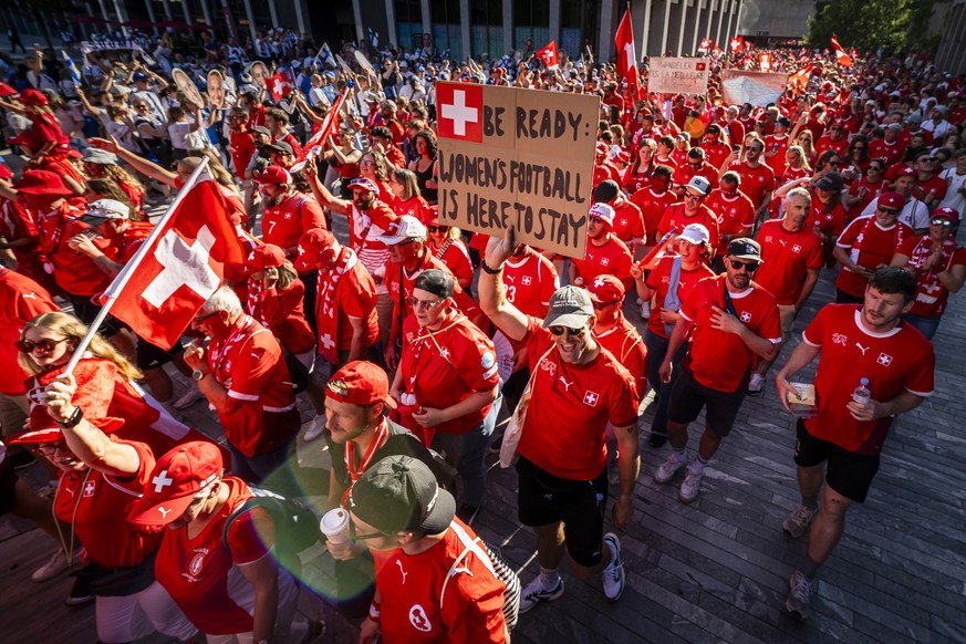 KEYPIX - Swiss fans walk towards the stadium holding flags and a placard reading &quot;Be ready: Women&#039;s Football is here to stay&quot; during a fanwalk prior to the UEFA Women&#039;s EURO 2025 G ...