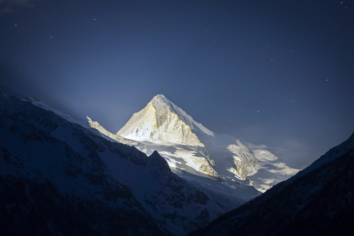 Dent Blanche mountain is illuminated with pyrotechnics during the 13 stars on the summit event, in "Les Hauderes" Val d'Herens, Switzerland, Wednesday, March 18, 2015. The 13 stars on t ...