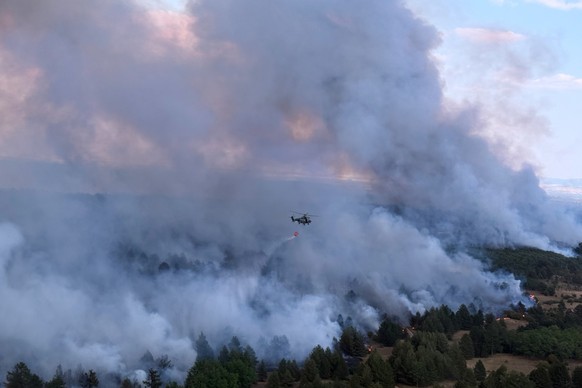In this photograph made available by the Serbian Ministry of Interior, a Serbian Police helicopter battles a fire in Deliblatska Pescara (Deliblato Sands), 70 kilometers north-west of Belgrade, Serbia ...