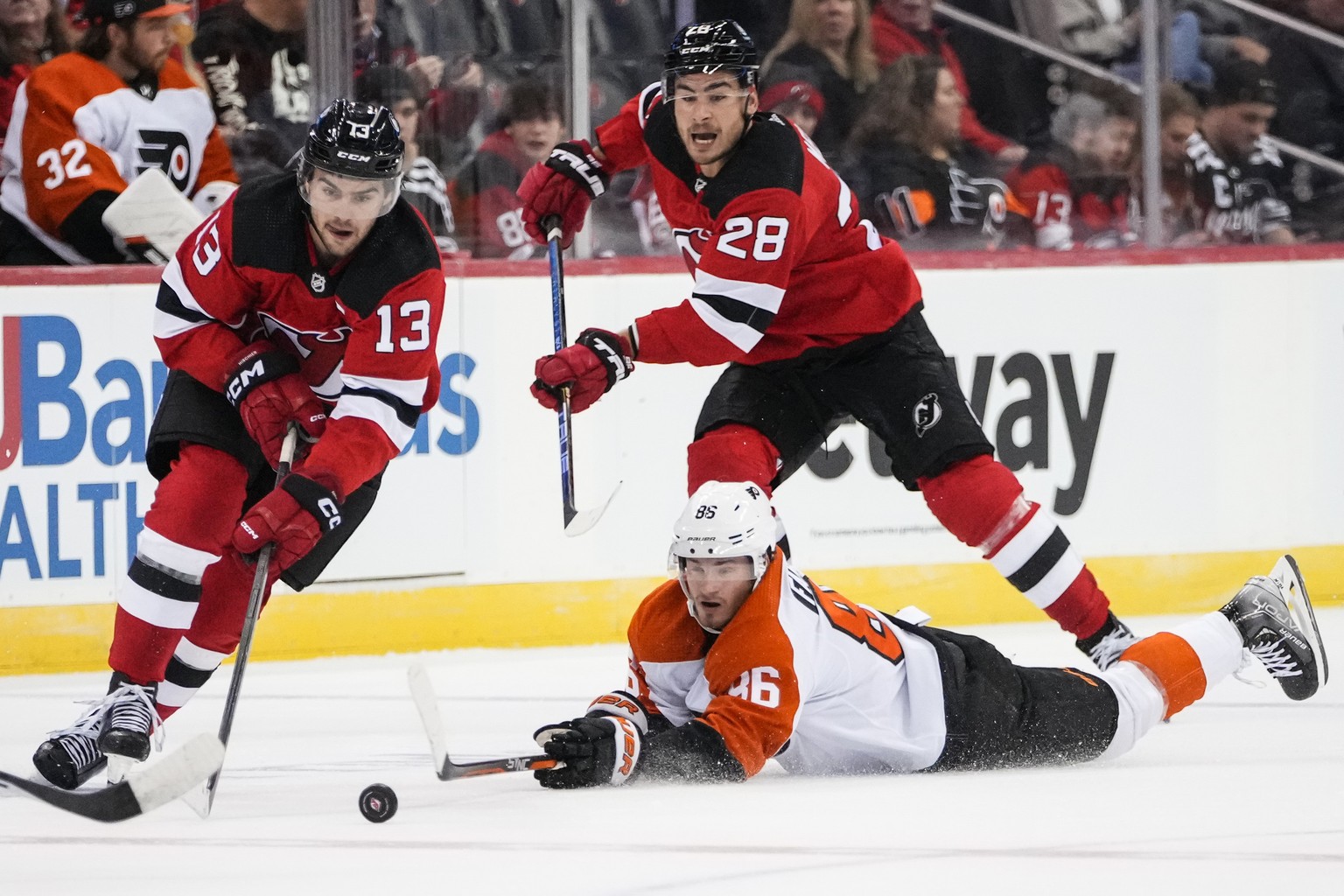New Jersey Devils&#039; Nico Hischier (13) drives past Philadelphia Flyers&#039; Joel Farabee (86) as Devils&#039; Timo Meier (28) watches during the second period of a preseason NHL hockey game, Mond ...