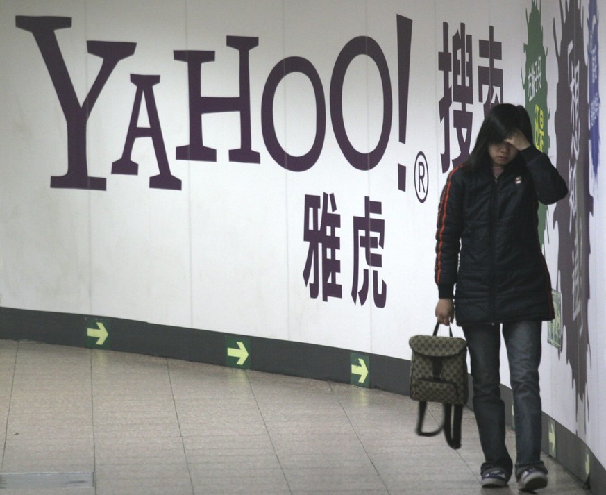 FILE - A woman walks past a Yahoo billboard in a Beijing subway in this March 17, 2006. Yahoo Inc. on Tuesday, Nov. 2, 2021 said it plans to pull out of China, citing an &quot;increasingly challenging ...