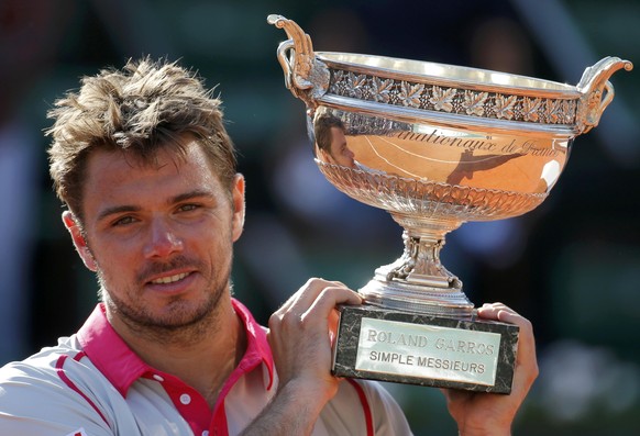 Stan Wawrinka of Switzerland poses with the trophy during the ceremony after winning the men&#039;s singles final match against Novak Djokovic of Serbia at the French Open tennis tournament at the Rol ...