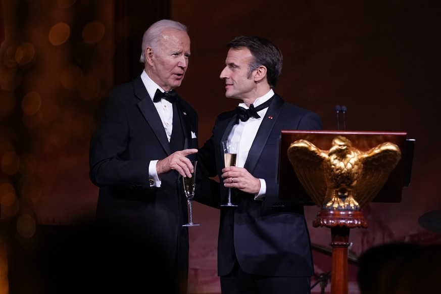President Joe Biden and French President Emmanuel Macron talk after a toast during a State Dinner on the South Lawn of the White House in Washington, Thursday, Dec. 1, 2022. (AP Photo/Andrew Harnik)