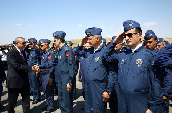 epa05447479 A handout picture provided by the Turkish President Press office shows Turkish President Recep Tayyip Erdogan (L) shaking hands with security personnel on a visit to the Turkish police spe ...