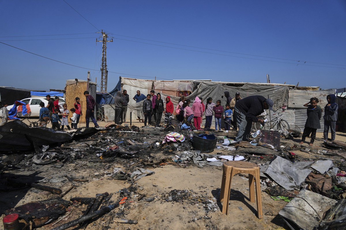 Palestinians inspect the remains of a displacement tent hit by an Israeli airstrike overnight, killing 10 members of the Abu Al-Rous family, in Khan Younis, southern Gaza Strip, Thursday, April 17, 20 ...