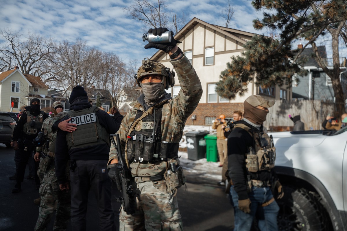 epa12645182 A US Border Patrol agent holds up a tear gas canister towards residents during a confrontation in Minneapolis, Minnesota, USA, 12 January 2026. As part of a federal immigration crackdown i ...