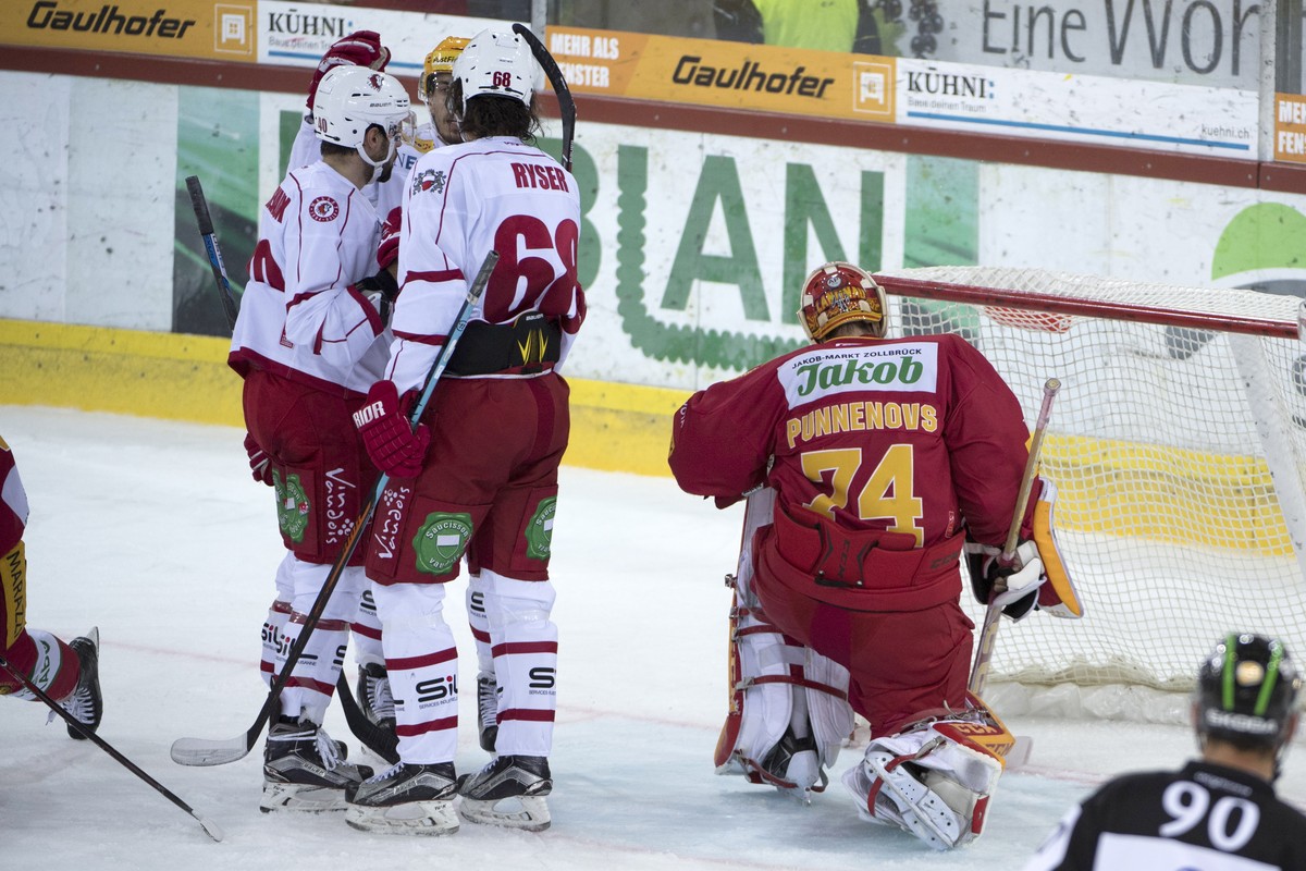 Tigers Goalie Ivars Punnenovs, rechts, ist geschlagen, Lausannes Etienne Froidevaux, Yannick Herren und Sven Ryser, von links, jubeln, waehrend dem Eishockey National League A Spiel zwischen den SCL T ...