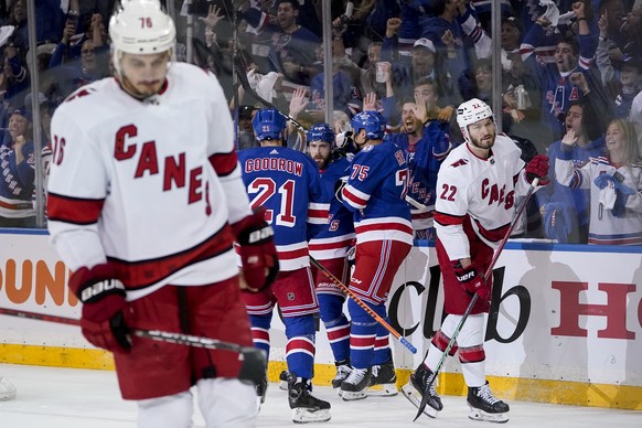 New York Rangers center Tyler Motte, center, celebrates with center Barclay Goodrow (21) and right wing Ryan Reaves (75) after scoring on Carolina Hurricanes goaltender Antti Raanta (32) during the first period of Game 6 of an NHL hockey Stanley Cup second-round playoff series, Saturday, May 28, 2022, in New York. (AP Photo/John Minchillo)