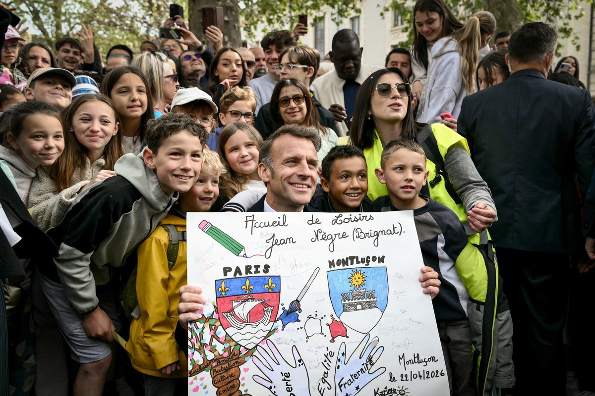 epa12906151 France's President Emmanuel Macron poses with local school pupils as he leaves after chairing a weekly cabinet meeting in the central France city of Montlucon, 22 April 2026. EPA/JEFF ...