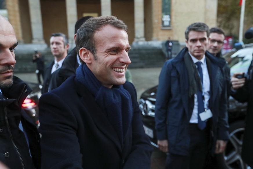 French President Emmanuel Macron, center, smiles as he greets visitors after a visit to the restoration atelier of The Adoration of the Mystic Lamb at the MSK Museum in Ghent, Belgium, Monday, Nov. 19 ...