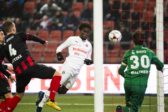 L&#039;attaquant genevois Koro Kone, centre, marque le premier but au gardien neuchatelois Laurent Walthert, droite, lors de la rencontre de football de Super League entre Neuchatel Xamax FCS et Serve ...