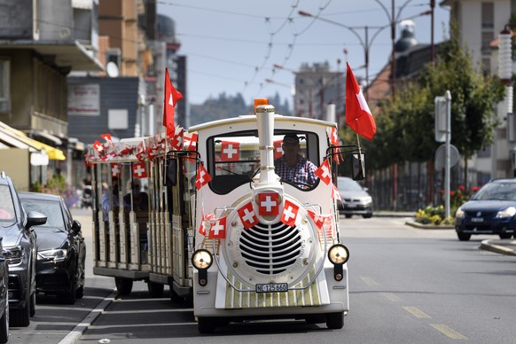 Des musiciens jouent de l&#039;accordeon a bord d&#039;un petit train touristique arpantant les rues de la cite horlogere afin d&#039;eviter tout attroupement lors de la fete nationale Suisse du 1er a ...