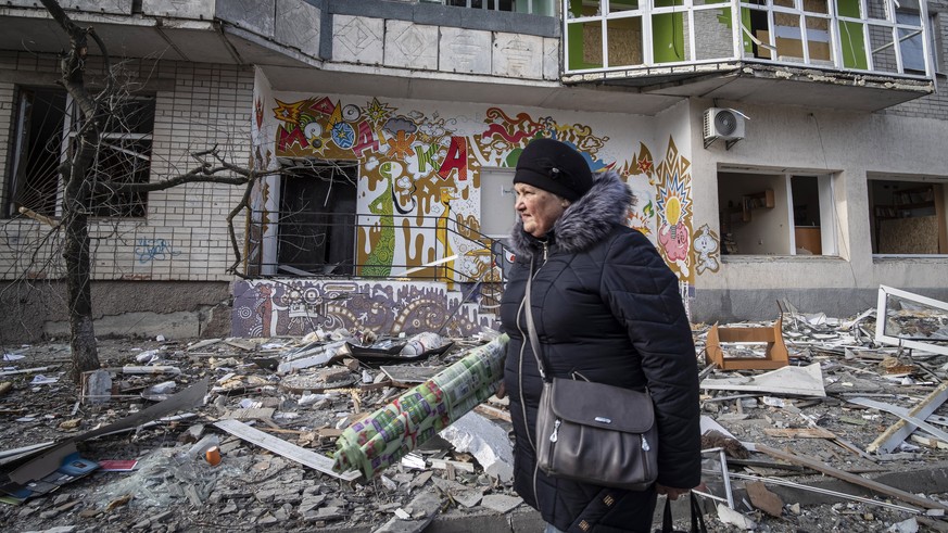 epa10375640 A resident passes a destroyed residential building following overnight shelling in Kherson, Ukraine, 21 December 2022. Ukrainian troops entered Kherson on 11 November after the Russian arm ...