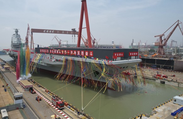 In this photo released by Xinhua News Agency, coloured smoke mark the launch ceremony for China&#039;s third aircraft carrier christened Fujian at a dry dock in Shanghai on Friday, June 17, 2022. Chin ...