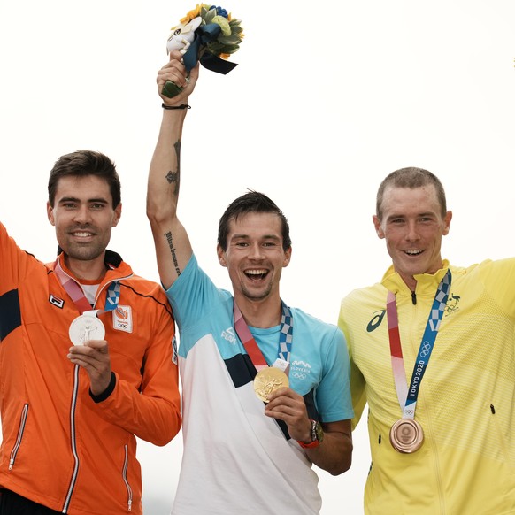 Gold medal winner Primoz Roglic of Slovenia, center, celebrates with silver medalist Tom Dumoulin of The Netherlands, left, and bronze medalist Rohan Dennis of Australia at a medal ceremony for the me ...