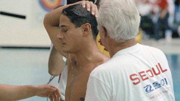 Diver Grefg Louganis of the U.S. rubs his head after hitting the springboard in the ninth dive of preliminary diving competition at the Summer Olympic Games in Seoul, Korea, Sept. 19, 1988. Louganis w ...