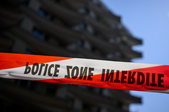 epa09846343 A ribbon of the Vaud cantonal police is visible in front of the scene of the tragedy where four people were found dead and one seriously injured at the foot of a building after reportedly  ...