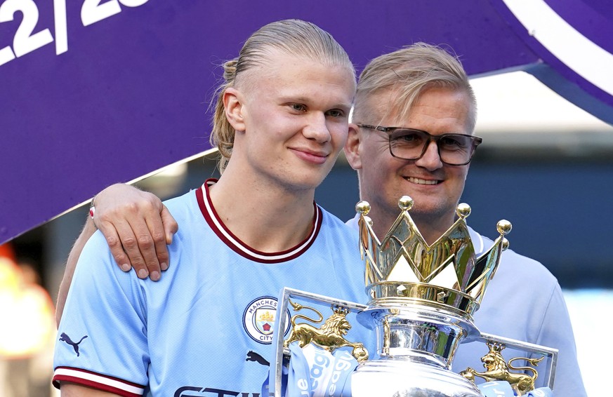 Manchester City&#039;s Erling Haaland and his father Alf-Inge Haaland pose for a photo with the Premier League trophy after their English Premier League title win at the end of the English Premier Lea ...