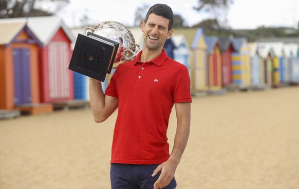 Serbia&#039;s Novak Djokovic reacts as he poses for photos with the Norman Brookes Challenge Cup at Brighton Beach after defeating Russia&#039;s Daniil Medvedev on Sunday Feb. 21, 2021 in the men&#039 ...