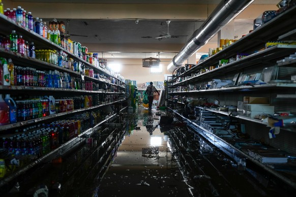 With the permission of the supermarket owner, a resident helps himself to supplies and food in Black River, Jamaica, Thursday, Oct. 30, 2025, in the aftermath of Hurricane Melissa. (AP Photo/Matias De ...