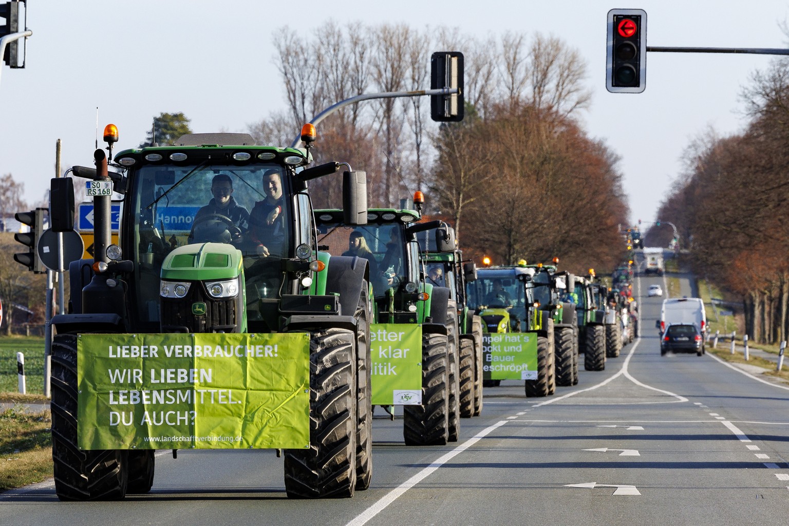 epa11064335 A banner hangs on a tractor that reads &#039;Dear consumer! We love foods. You too?&#039; (L) as farmers drive their tractors on federal road B1 during a nationwide farmers&#039; strike ne ...